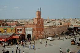 Image du Maroc Professionnelle de  Le fidèles accèdent à la Mosquée Kharbouche pour la prière d'Al Asr, cette mosquée située au bout de la fameuse place Jemaa El Fana à sa gauche l'entrée du souk Semmarine et à droite le Derb Dabachi un important passage de la médina de Marrakech, la ville touristique du Maroc. La 4L (voiture Renault 4) est bloqué par un sabot à cette époque déjà, il était strictement interdit de stationner tout le long du mur de la mosquée d'ailleurs plusieurs panneaux le rappel. Jeudi 19 Mai 1988. (Photo / Abdeljalil Bounhar) 